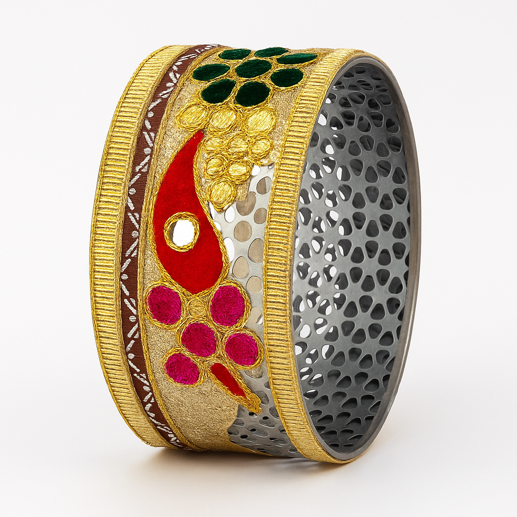 Decorative bangle with gold, red, and green design on a white background